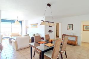 een eetkamer en een woonkamer met een tafel en stoelen bij Terraza con vistas en Alcaidesa in Alcaidesa