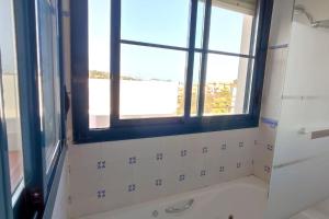 een badkamer met een raam en een bad bij Terraza con vistas en Alcaidesa in Alcaidesa