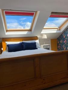 um quarto com uma cama grande e 2 janelas em ByTheSea em Malahide