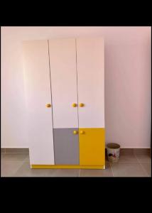 a white and yellow cabinet in a room at قريه امواج الساحل الشمالى in Sīdī ‘Abd ar Raḩmān