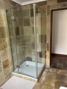 a shower with a glass door in a bathroom at Mi Casita in Graskop