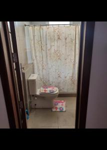 a bathroom with a toilet and a shower curtain at قريه امواج الساحل الشمالى in Sīdī ‘Abd ar Raḩmān