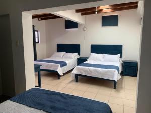 - une chambre avec 2 lits avec des draps bleus et blancs dans l'établissement Hotel & Hostal Santuario, à San Miguel de Allende