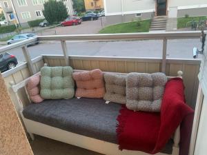 a bench with pillows sitting on a balcony at Charming Downtown Gem in Linköping