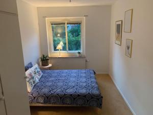 a bedroom with a blue bed and a window at Charming Downtown Gem in Linköping