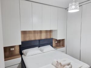 1 dormitorio con 1 cama con armarios blancos en Hera's Home, en Tirana
