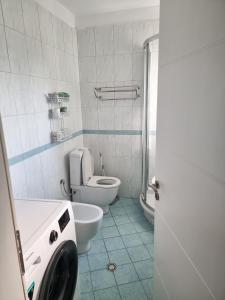 La salle de bains est pourvue de toilettes et d'un lave-linge. dans l'établissement Hera's Home, à Tirana