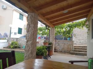un patio con una pérgola de madera y una mesa en Apartments Janjac, en Vodice