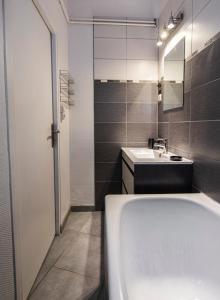 a bathroom with a tub and a sink and a mirror at Appartement tout confort hyper centre, proche gare avec balcon in Tours +18 photos