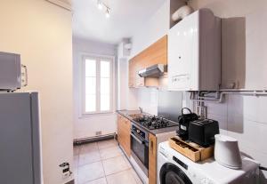uma pequena cozinha com um fogão e um frigorífico em Affaire et séjour appart tout confort, à 250 m de la gare, hyper centre em Tours