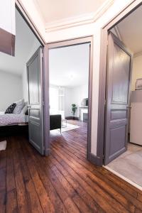uma porta aberta num quarto com pisos em madeira em Affaire et séjour appart tout confort, à 250 m de la gare, hyper centre em Tours