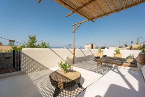 a patio with a table and a bench on a roof at Icos village house in Hersonissos