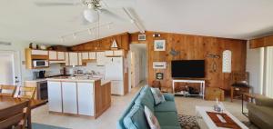 uma sala de estar com um sofá azul e uma cozinha em The Butterfly Cottage em Marathon