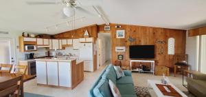 a living room with a blue couch and a kitchen at The Butterfly Cottage in Marathon