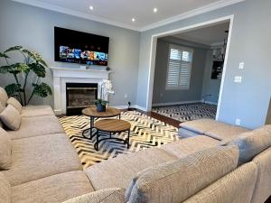a living room with a couch and a fireplace at Cozy 5 Bedroom House Mississauga in Mississauga