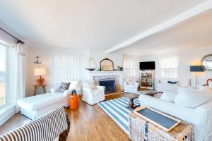 uma sala de estar com mobiliário branco e uma lareira em Sea Cliff Cottage em Lincoln City