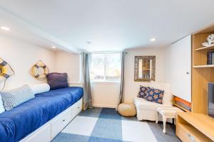 a bedroom with a blue couch and a window at Sea Cliff Cottage in Lincoln City