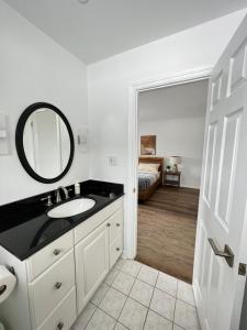 baño con lavabo, espejo y cama en Letitia Heights !E Spacious and Quiet Private Bedroom with Private Bathroom en Barrie