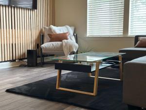 a living room with a glass coffee table and a chair at EasyStays Alexandria in Alexandria