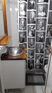 a bathroom with a sink and a wall of photos at Departamento Plaza Colón, Mar del Plata in Mar del Plata