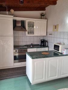 a kitchen with white cabinets and a counter top at Apartments with a parking space Palit, Rab - 4983 in Rab