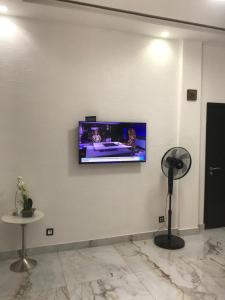 einen Flachbild-TV an einer weißen Wand in der Unterkunft Seckebe immo et Business STUDIO DAKAR Suite 4 in Dakar