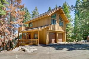 a wooden house with a garage in the woods at Dock Access and Hot Tub Waterfront Meeks Bay Home in Tahoma