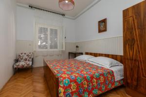 a bedroom with a large bed with a colorful blanket at Apartments by the sea Sumpetar, Omis - 949 in Jesenice