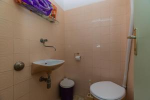 a small bathroom with a toilet and a sink at Apartments by the sea Sumpetar, Omis - 949 in Jesenice +13 photos