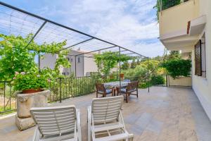 eine Terrasse mit einem Tisch und Stühlen auf dem Balkon in der Unterkunft Apartments with a parking space Mali Losinj (Losinj) - 7879 in Mali Lošinj