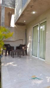 a patio with two benches on a house at Habitación Triple Equipada, Posada Villa Mayo a 5 minutos de Playa Parguito in Loma de Guerra