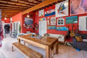a dining room with a wooden table and red walls at Guest House Vida Vibra in Ubatuba