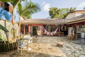 Cette maison dispose d'une terrasse avec des chaises et une table. dans l'établissement Guest House Vida Vibra, à Ubatuba