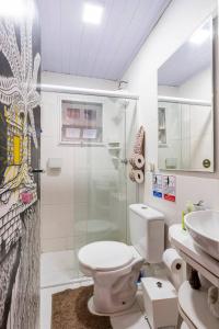 a bathroom with a shower and a toilet and a sink at Guest House Vida Vibra in Ubatuba