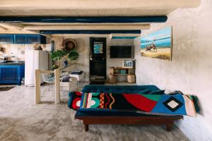 ein Wohnzimmer mit Couch und Küche in der Unterkunft Casinha Azul Caraíva - casa completa na beira do Rio in Caraíva