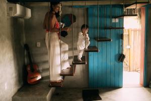 eine Frau und ein Kind gehen in einem Zimmer die Treppe hinunter in der Unterkunft Casinha Azul Caraíva - casa completa na beira do Rio in Caraíva + 47 Fotos