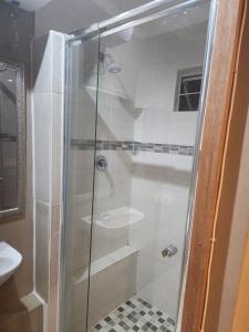 a shower with a glass door in a bathroom at Charles Court Guest House in Durban