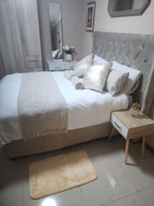 a bedroom with a large bed and a table at Charles Court Guest House in Durban