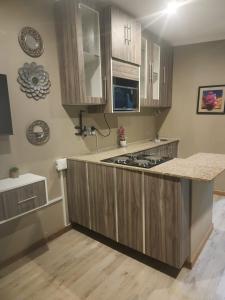a kitchen with wooden cabinets and a counter top at Charles Court Guest House in Durban