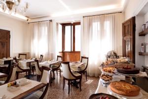 a restaurant with tables and chairs with food on them at Hotel Dell'Opera in Venice