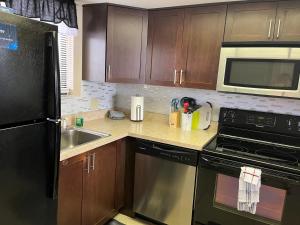 een keuken met een zwarte koelkast en een wastafel bij Cozy Gulf of Mexico Resort Condo #603 in Hudson in Hudson