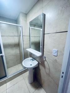 a bathroom with a sink and a shower and a mirror at Entre Ríos Alquileres Temporarios. in Paraná