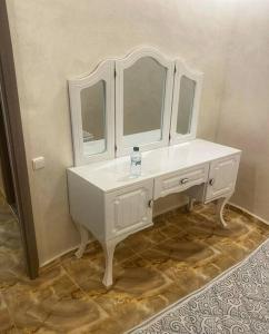 a white bathroom with a sink and mirrors at Appart moderne à côté d'Ouasiria in Marrakesh