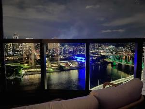 - une vue sur la ville depuis une fenêtre la nuit dans l'établissement Brisbane Riverfront Oasis 2Bed Panoramic RiverView, à Brisbane