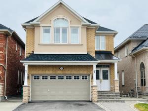 a house with a garage door in front of it at Cozy 5 Bedroom House near Toronto Airport in Mississauga