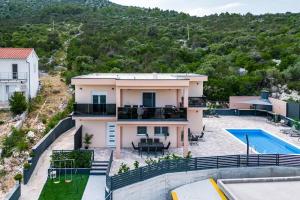 uma villa com uma piscina e uma casa em Family friendly apartments with a swimming pool Poljica, Trogir - 21592 em Marina