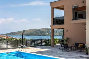 uma casa com piscina e vista para o oceano em Family friendly apartments with a swimming pool Poljica, Trogir - 21592 em Marina