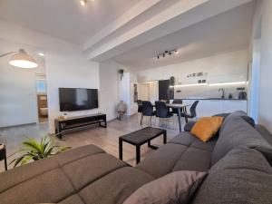 uma sala de estar com um sofá e uma sala de jantar em Family friendly apartments with a swimming pool Poljica, Trogir - 21592 em Marina