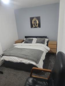 Decent Homes No 4- modern double room في Dukinfield: غرفة نوم مع سرير مع قناع على الحائط