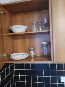 Decent Homes No 4- modern double room في Dukinfield: خزانة مع الأطباق والجرارات الزجاجية والأطباق